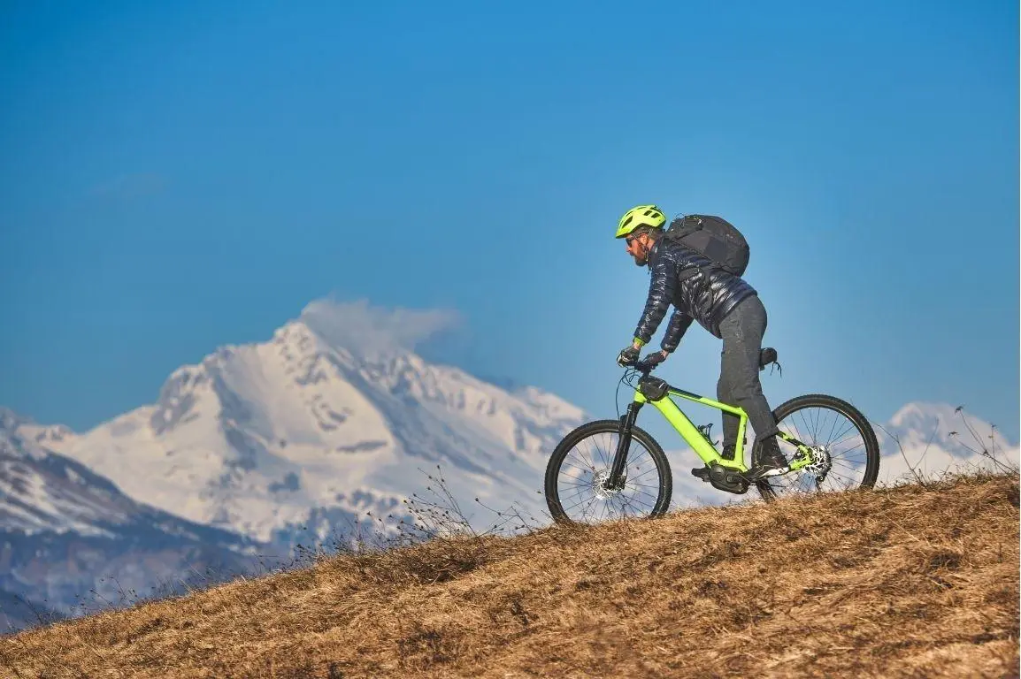 Cyclist riding through scenic mountain trails during a bike trek