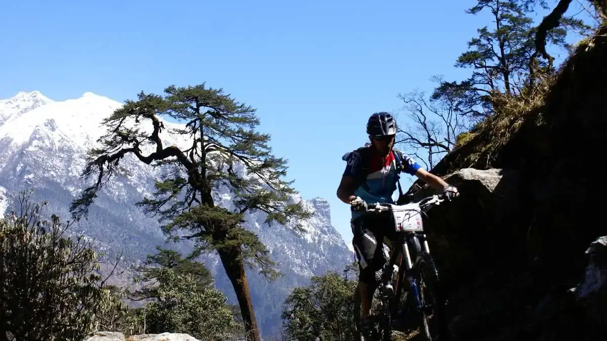 Cyclist passing through a traditional stone village in Manang